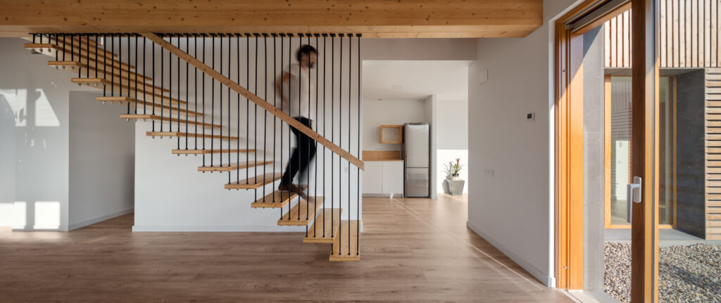 Imatge d'una persona baixant per unes escales en una casa passiva eskimohaus a Catalunya, que no té hipoteca energètica.